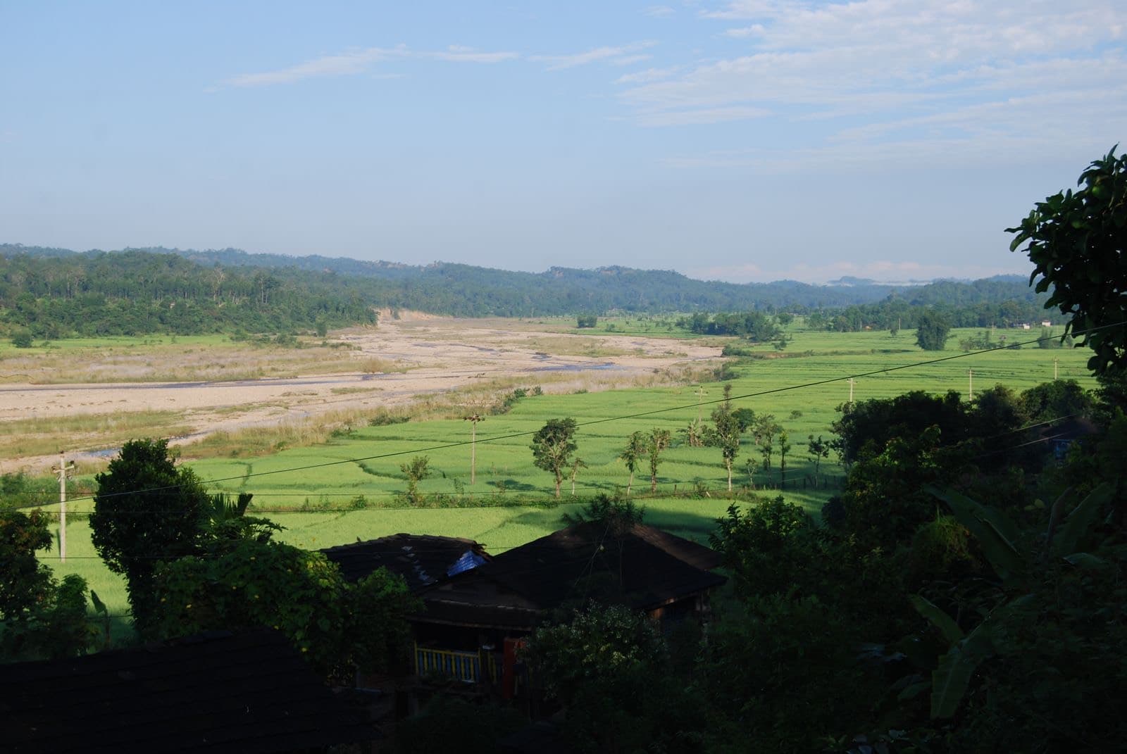 Green farmland and a river valley in rural Nepal